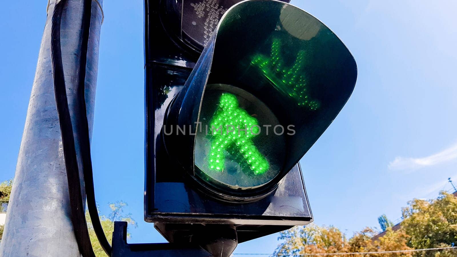 Traffic light with green light and safe for movement. Pedestrian traffic light. Green man.