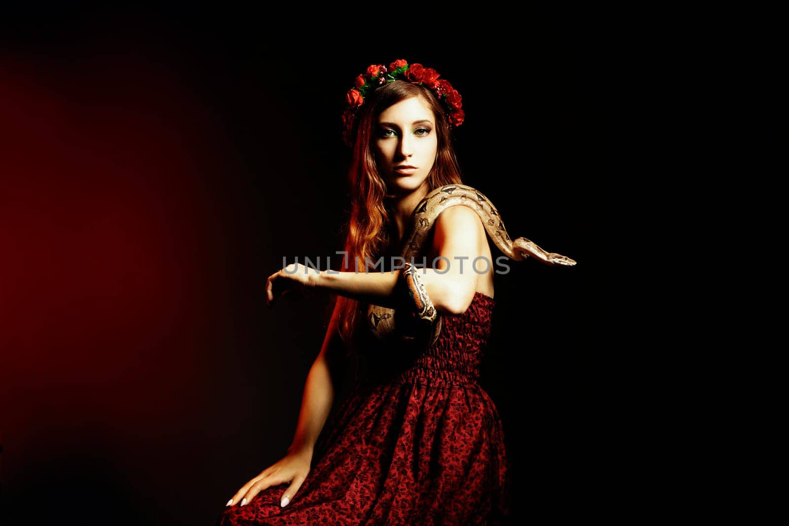 Attractive red haired woman posing with a boa constrictor