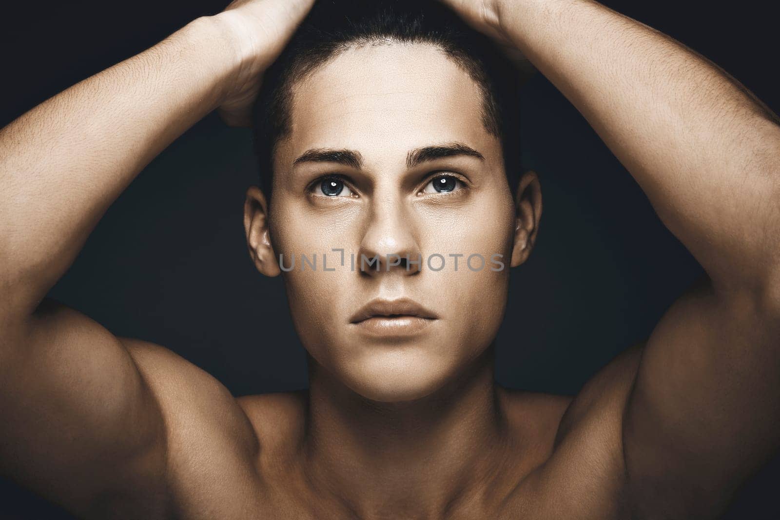Beauty portrait of young handsome man against blue background