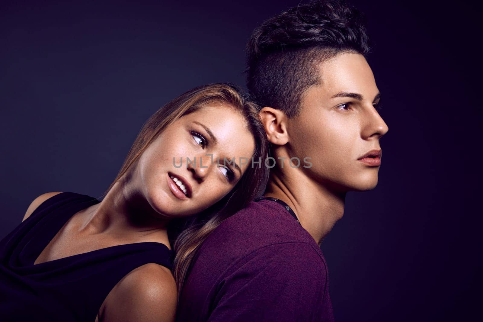 Fashion portrait of young beautiful couple against blue background