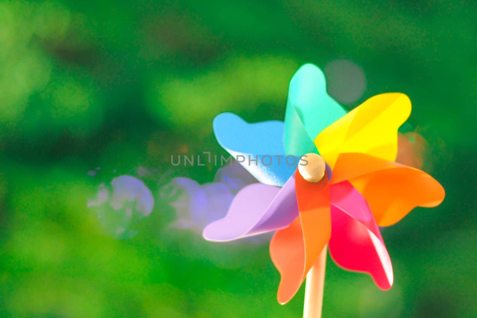 Colorful Pinwheel Toy Against green bokeh background of summer. Spinning pinwheel toy. Garden Ornaments Windmills & Wind Spinners Colorful Garden Wooden Handle Windmill Pinwheel Wind Spinner Yard decor