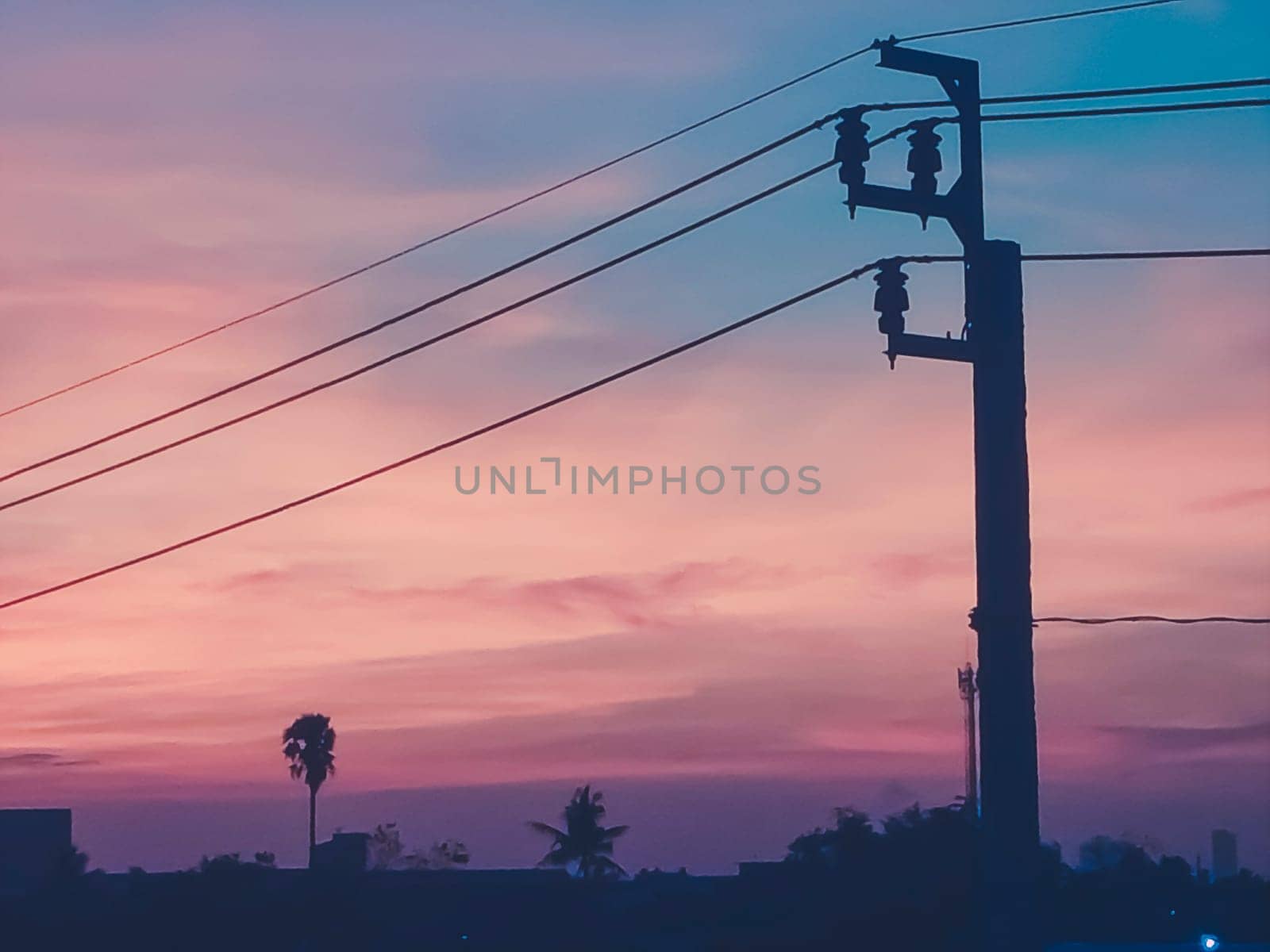 The electric pole and electric transformer at sunset orange sky