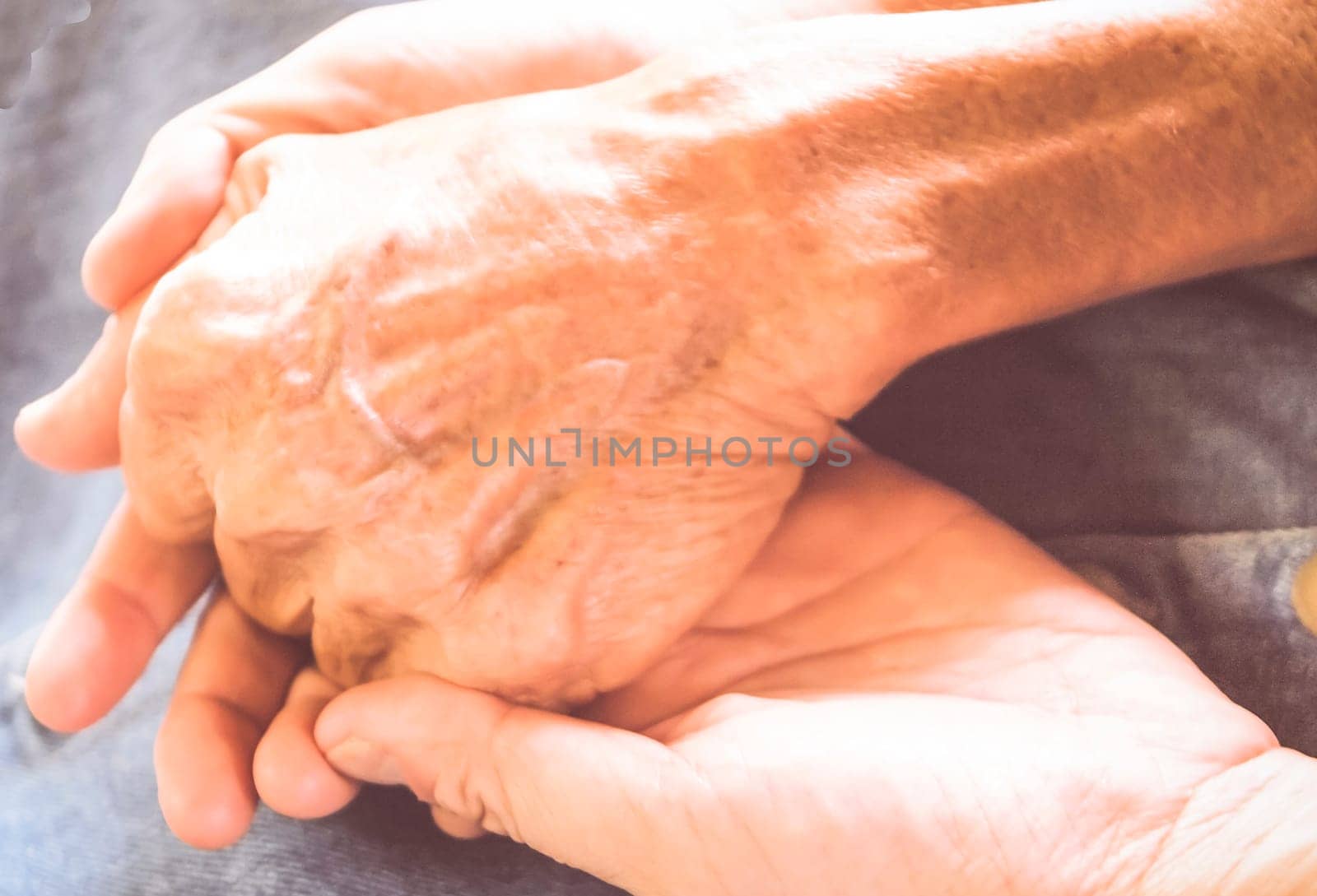 Old and young female holding hands . People, care and support. Giving helping hand concept .The concept of care and help for old people, the connection of the older and younger generation of people.