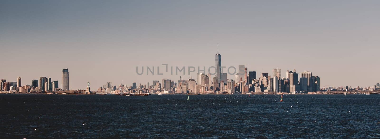 New York City Manhattan downtown skyline at dusk with skyscrapers illuminated over Hudson River panorama. Vertical composition.