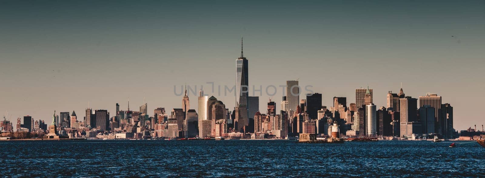 New York City Manhattan downtown skyline at dusk with skyscrapers illuminated over Hudson River panorama. Vertical composition.