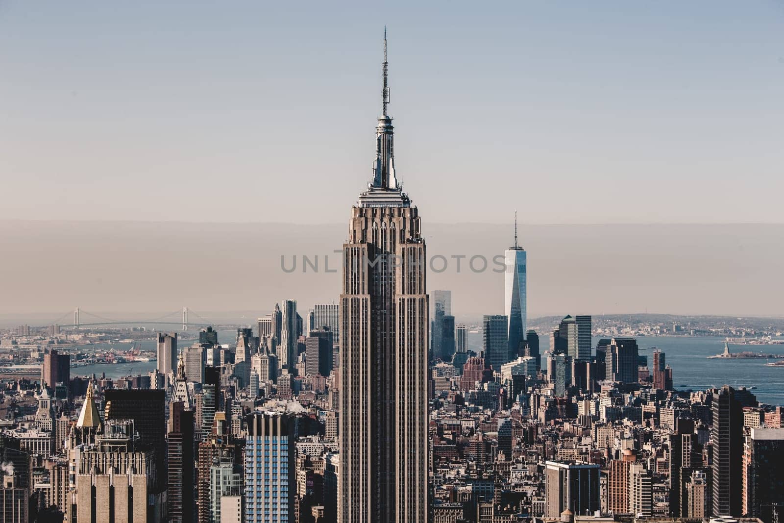 New York City. Manhattan downtown skyline with illuminated Empire State Building and skyscrapers at sunset.
