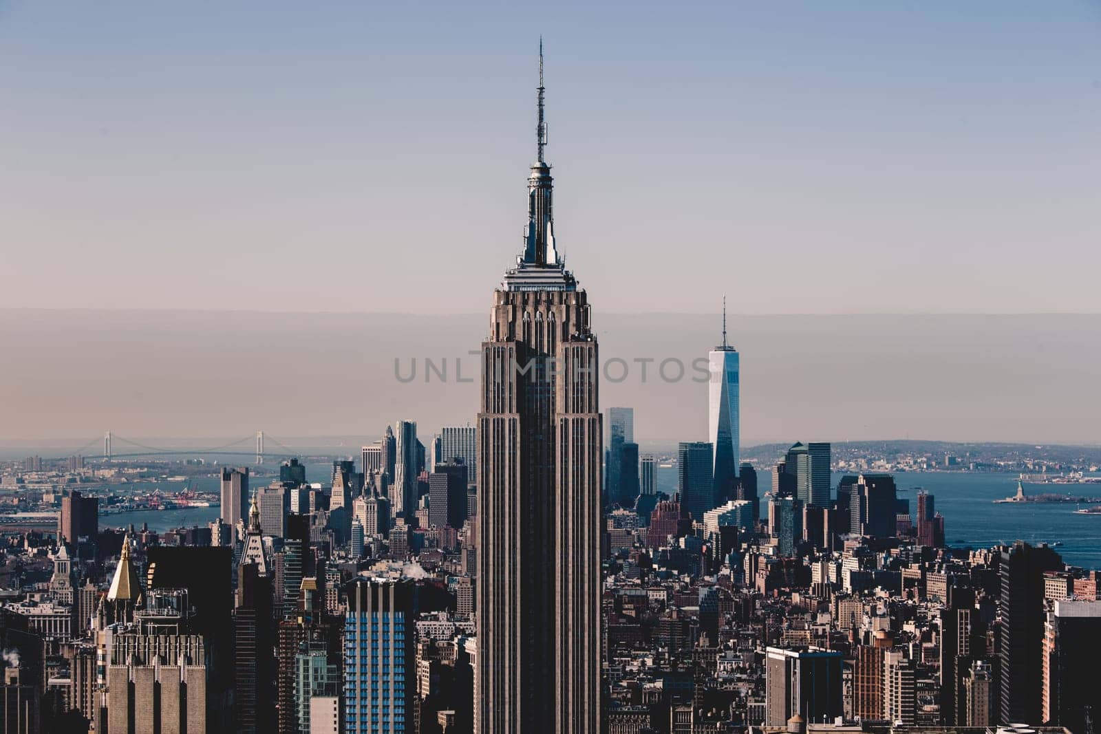 New York City. Manhattan downtown skyline with illuminated Empire State Building and skyscrapers at sunset.