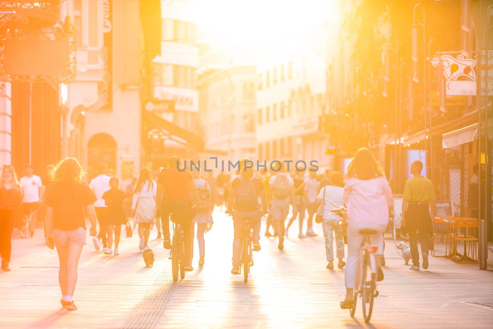 Blurred crowd of people on Copova pedestrian street in Ljubljana at sunset. Urban lifestyle and mobility concept