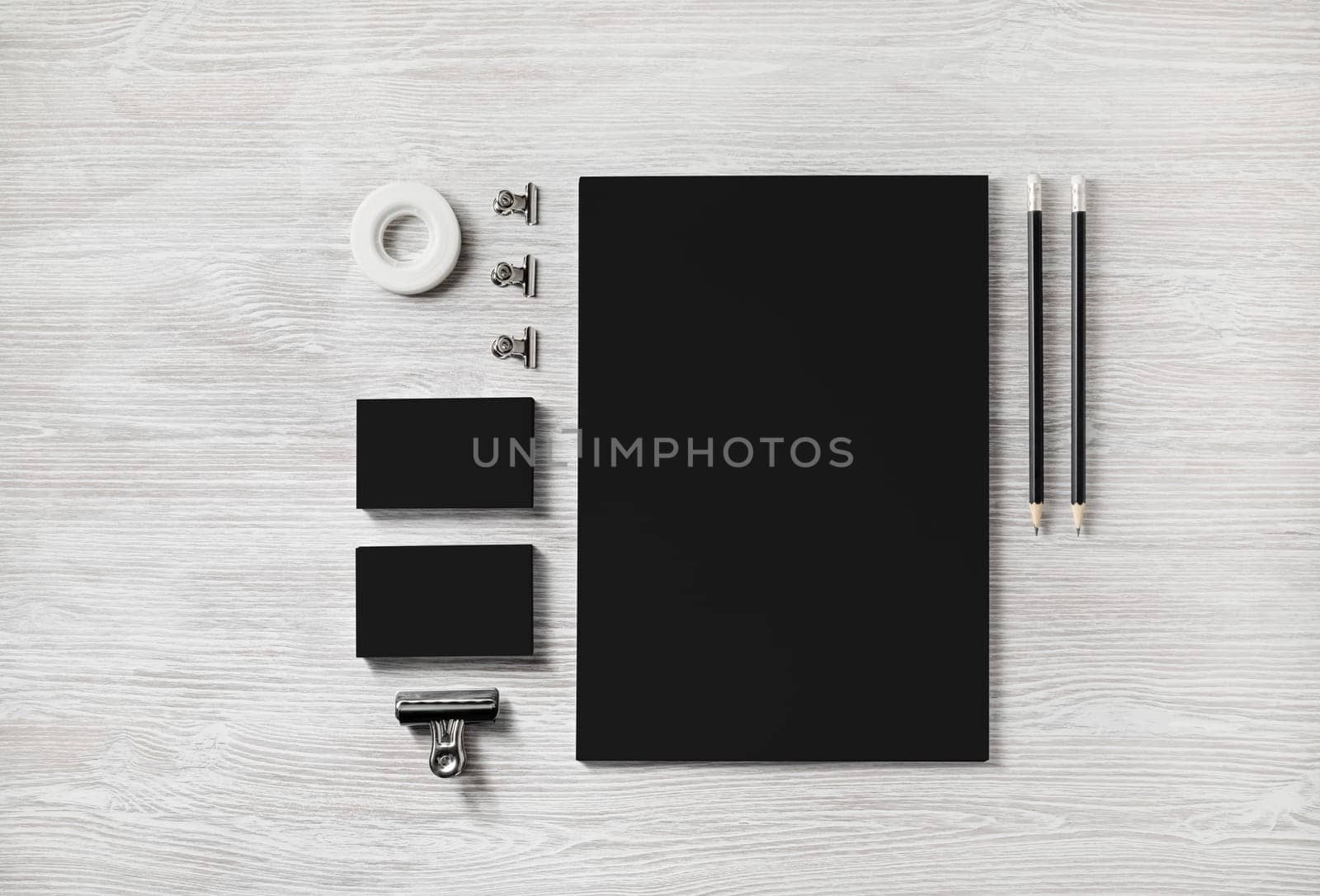 Blank black corporate stationery template on light wood table background. Mockup for design presentations and portfolios. Flat lay.