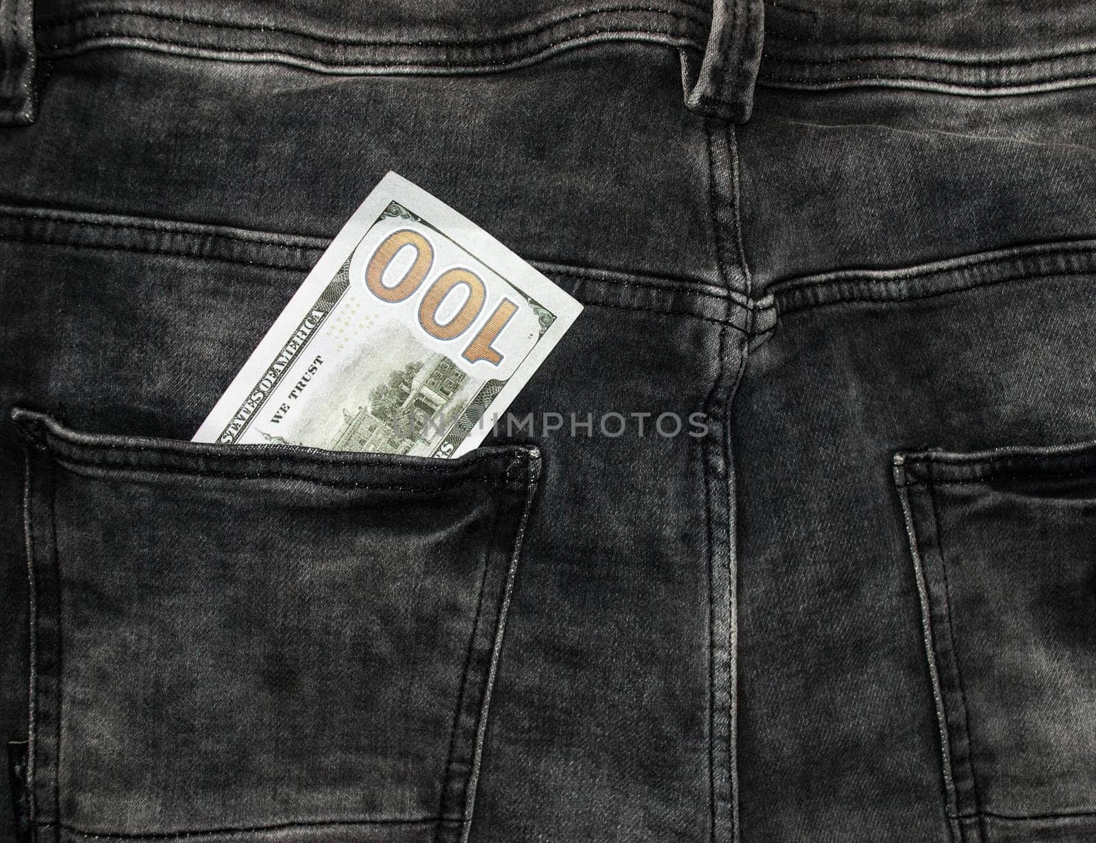 Many hundred dollar bills in jeans pocket. US dollars are visible in your pocket