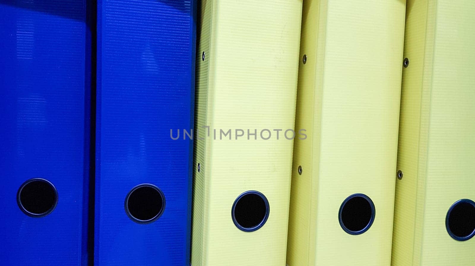 Various office folders on a supermarket shelf. Plastic and paper folders with documents are on the shelf of the cabinet