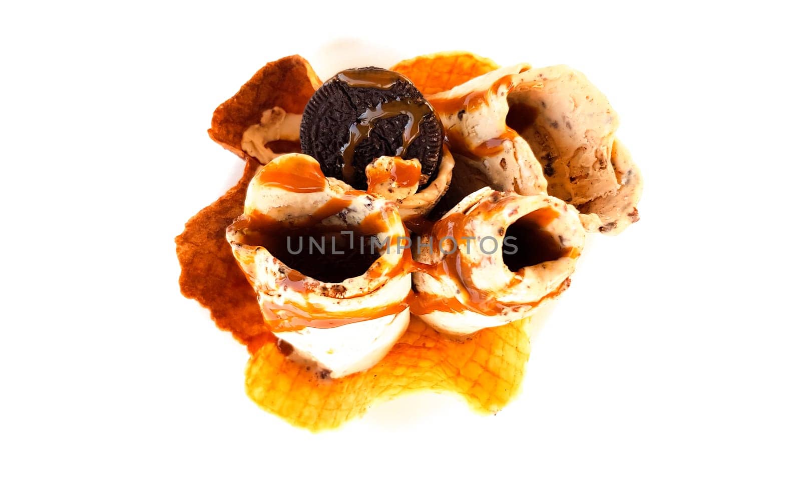 A serving of fried ice cream with caramelized banana cream cookies on a white table summer cafe.