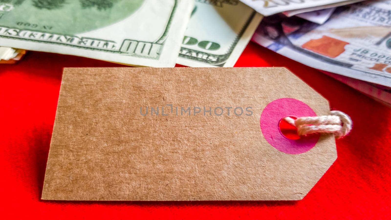Empty cardboard tag for the inscription Black Friday with American dollars on a red background. Background, holiday concept. Black Friday - International Day of Shopping, Promotions, Discounts, Sales. Sales season is the fourth Thursday of November. Copy space, place for text.