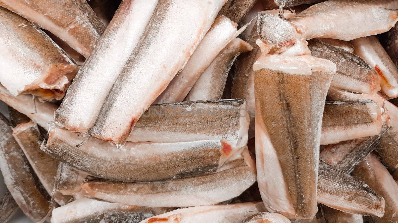 Frozen hake fish close-up. Lots of fish on the counter.
