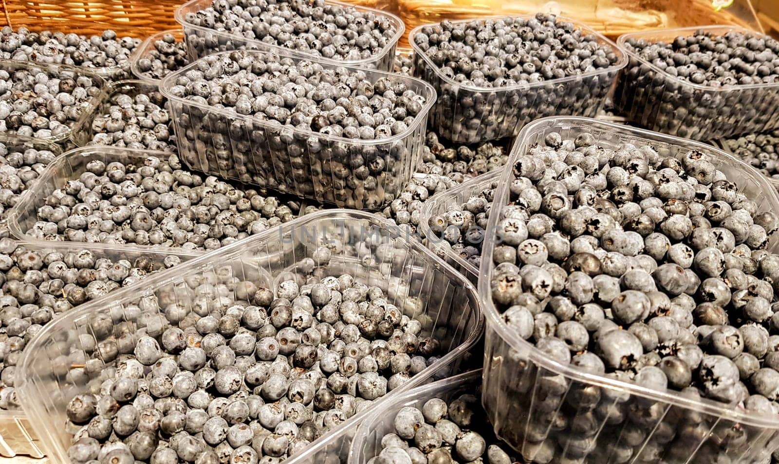 Fresh ripe artisan blueberries in mint containers. Healthy snacks are loaded with vitamins and minerals. Berries on a counter in a supermarket.