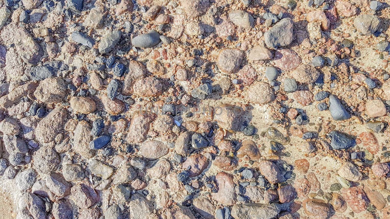 Background of Red sea water surface and sandy bottom. Sandy sea floor with structure of sunlight in the red sea