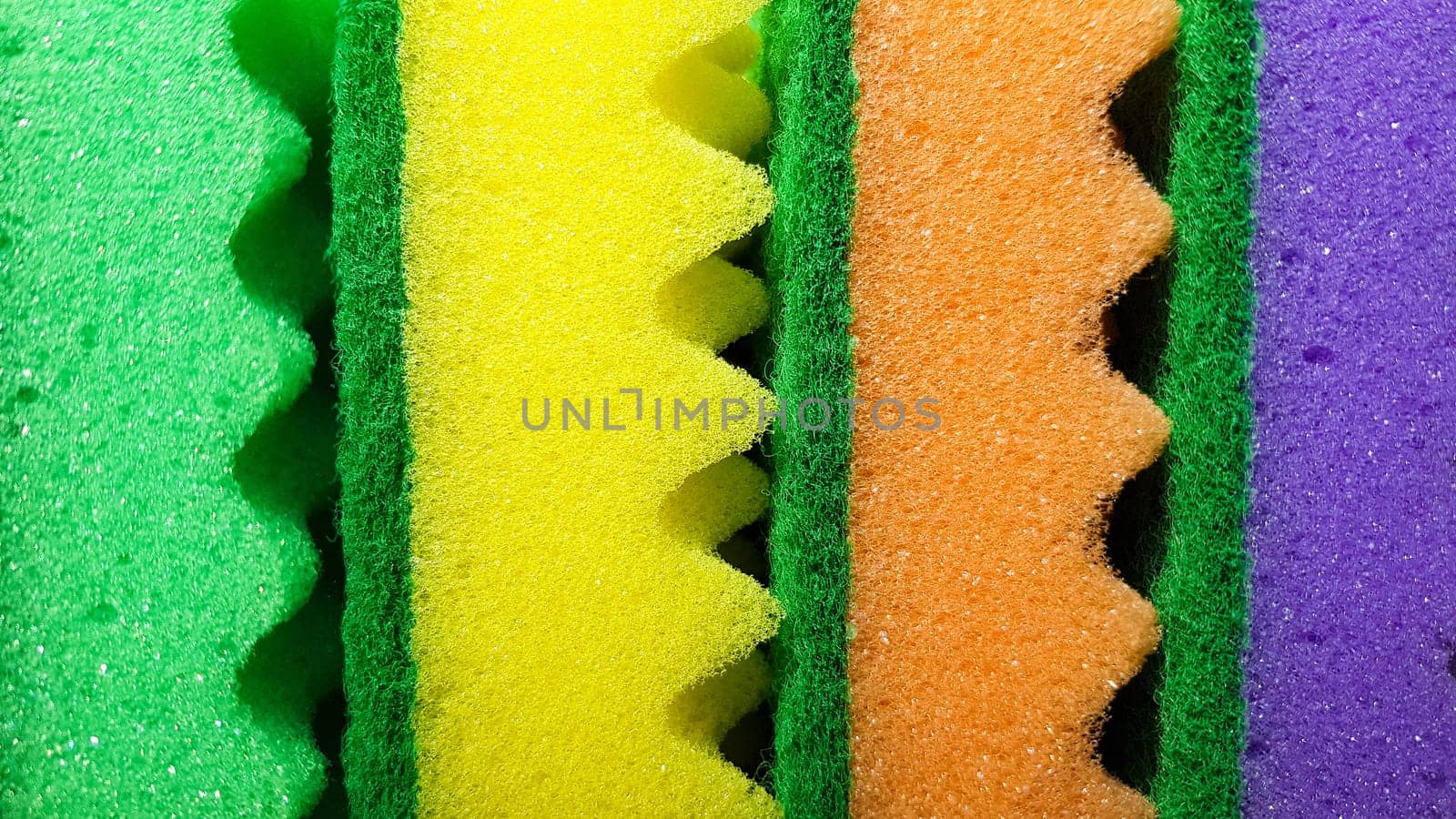 Multi-colored washcloths are laid out in rows on a bright background, close-up. place for text. Copy space.