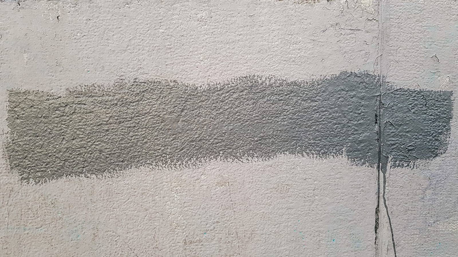 Gray concrete wall. Large coarse strokes of paint on the surface of the house. Close-up. Classic background. Copy space. Place for text