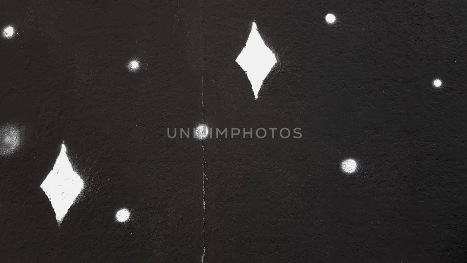 High-quality creative background for advertising, banners, holiday cards. Black concrete painted wall with white spots in the form of highlights or stars.
