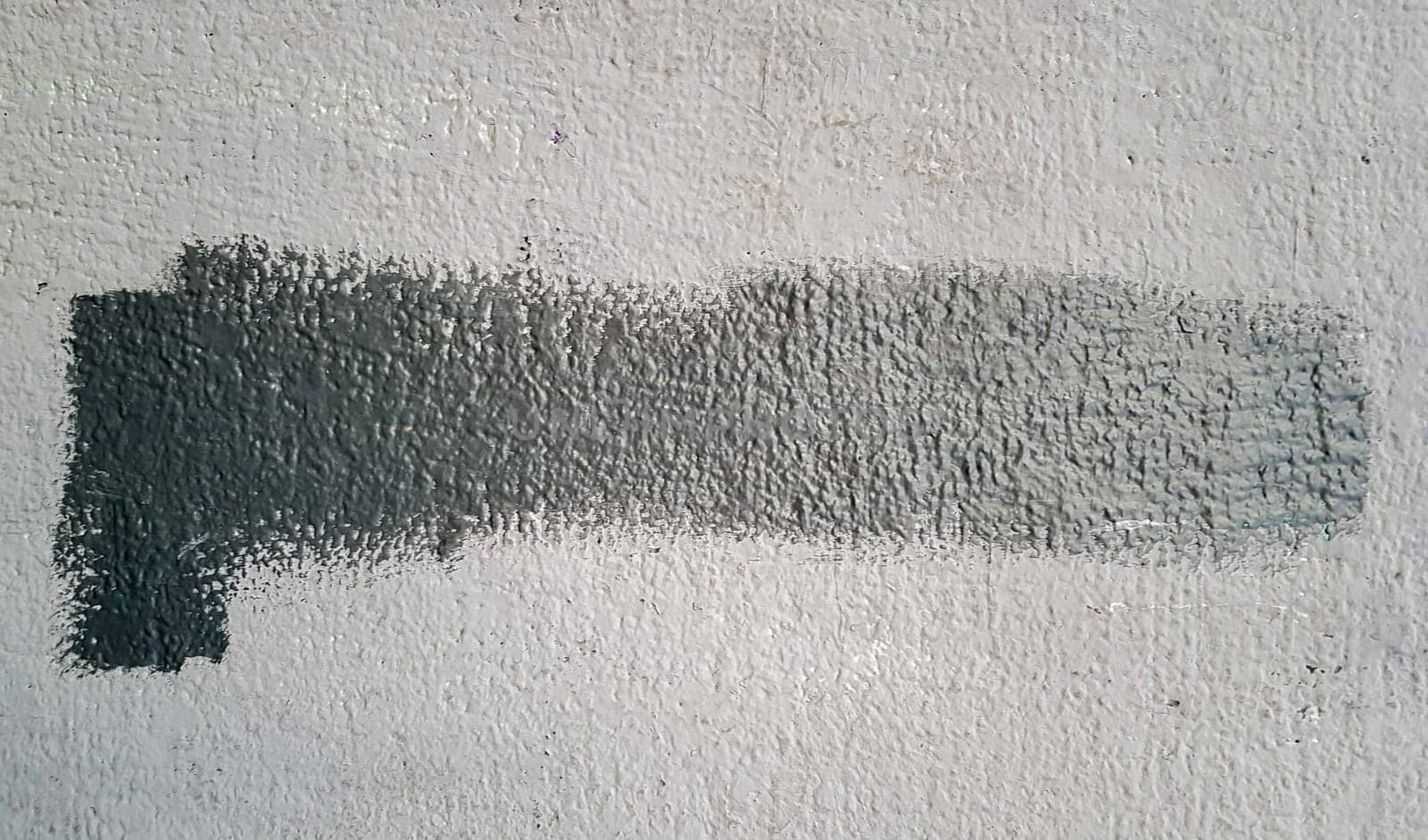 Gray concrete wall. Large coarse strokes of paint on the surface of the house. Close-up. Classic background. Copy space. Place for text