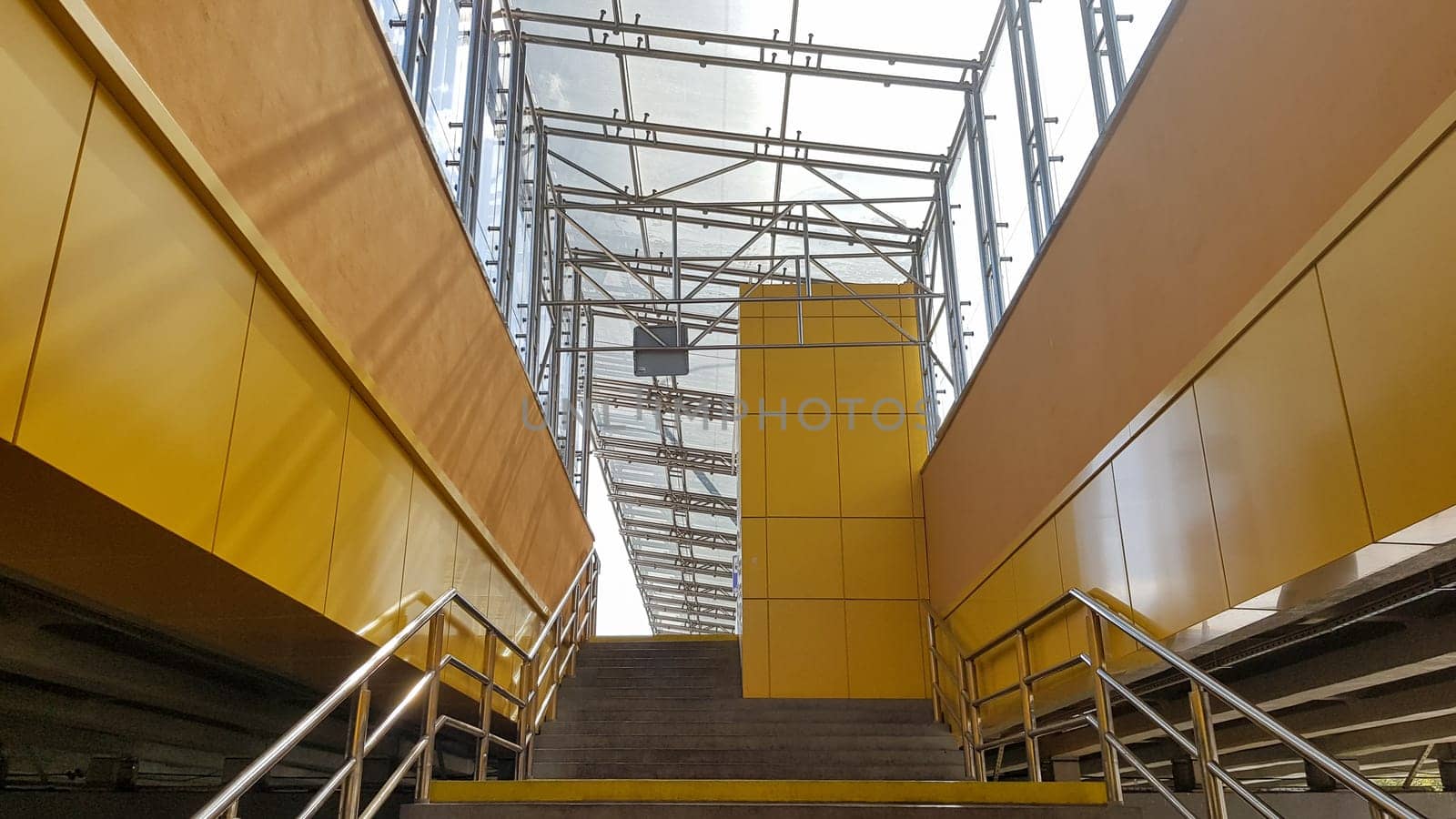 Ukraine, Kiev - September 24, 2019: light rail station. Design of a bus stop and a pedestrian underpass with steps and railings made of yellow panels and a glass roof