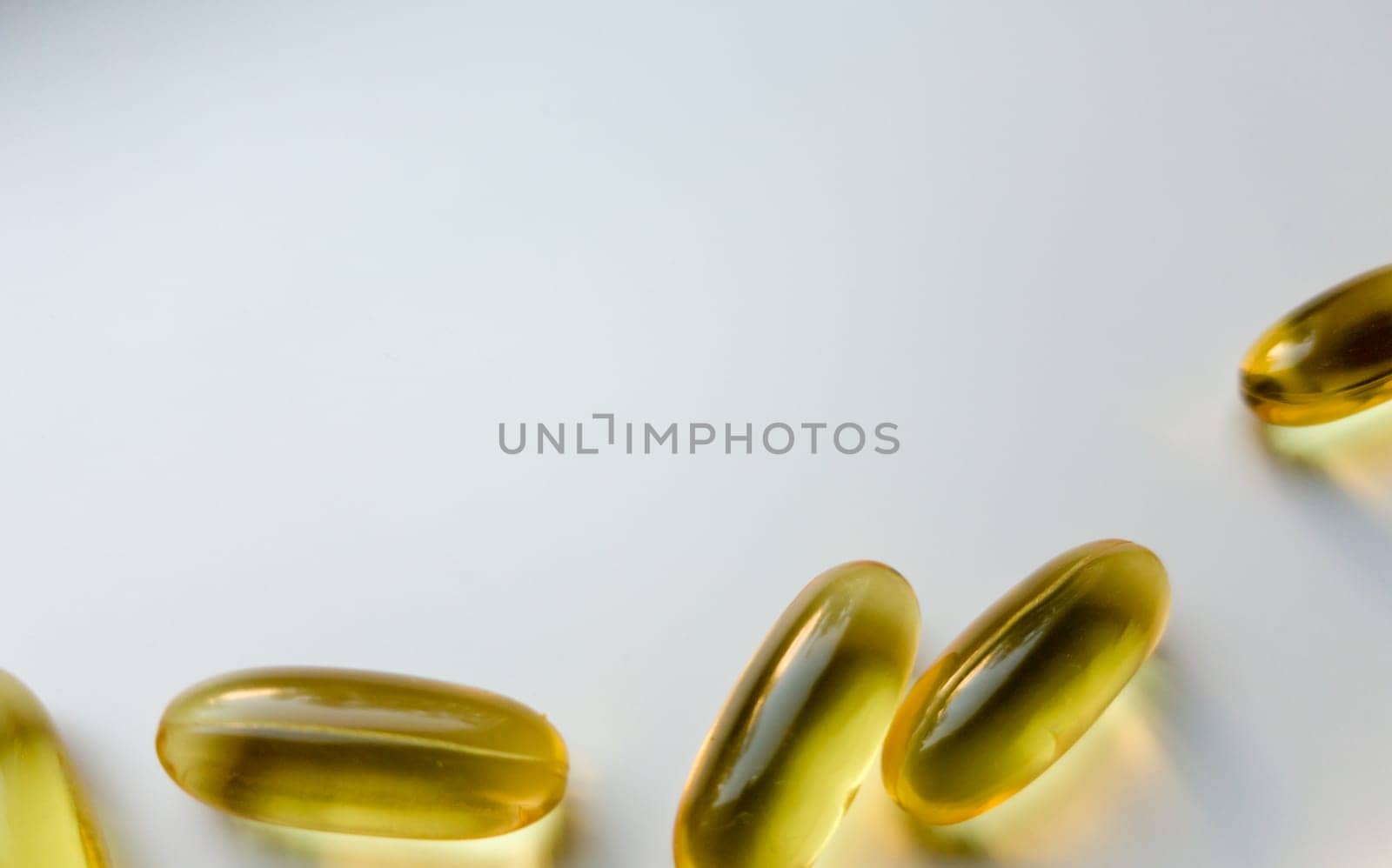 Fish oil capsules isolated on white background with copy space, top view. Omega-3 high resolution product. Food supplement. Healthy lifestyle. Fatty acids in tablets. Metabolism in the body