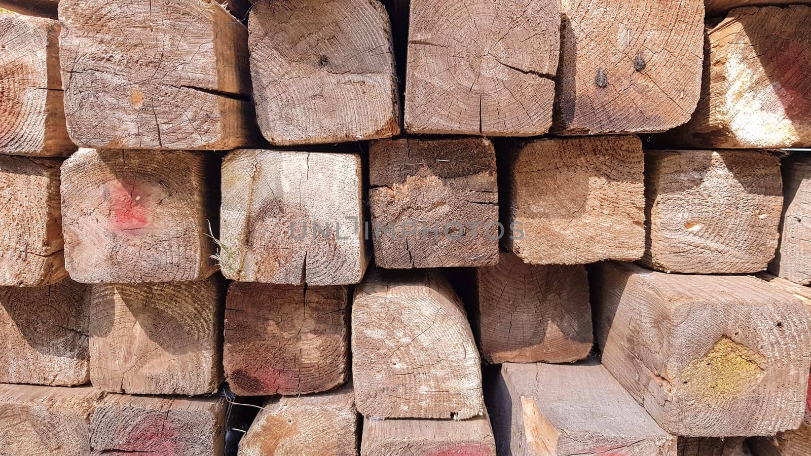 Stacked lumber. Folded wood.Closeup wooden boards.The surface of the end of the board.Lots of planks stacked on top of each other in the warehouse.Lumber for use in construction