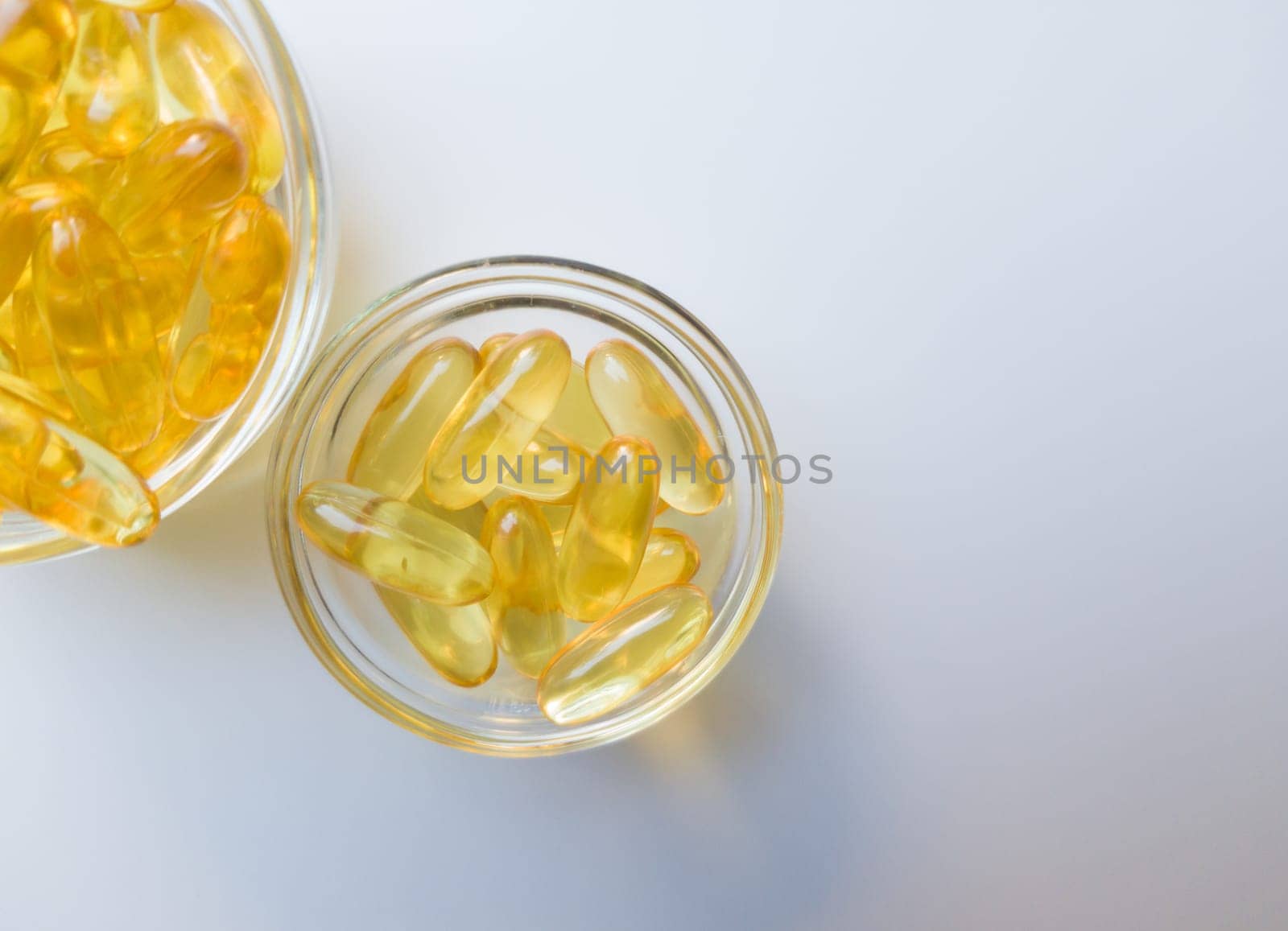 Fish oil capsules on a glass plate. A lot of vitamin omega 3 on a white background. Close-up, top view, high resolution product. Metabolism in the body. The body of calcium. A quick way to lose weight.