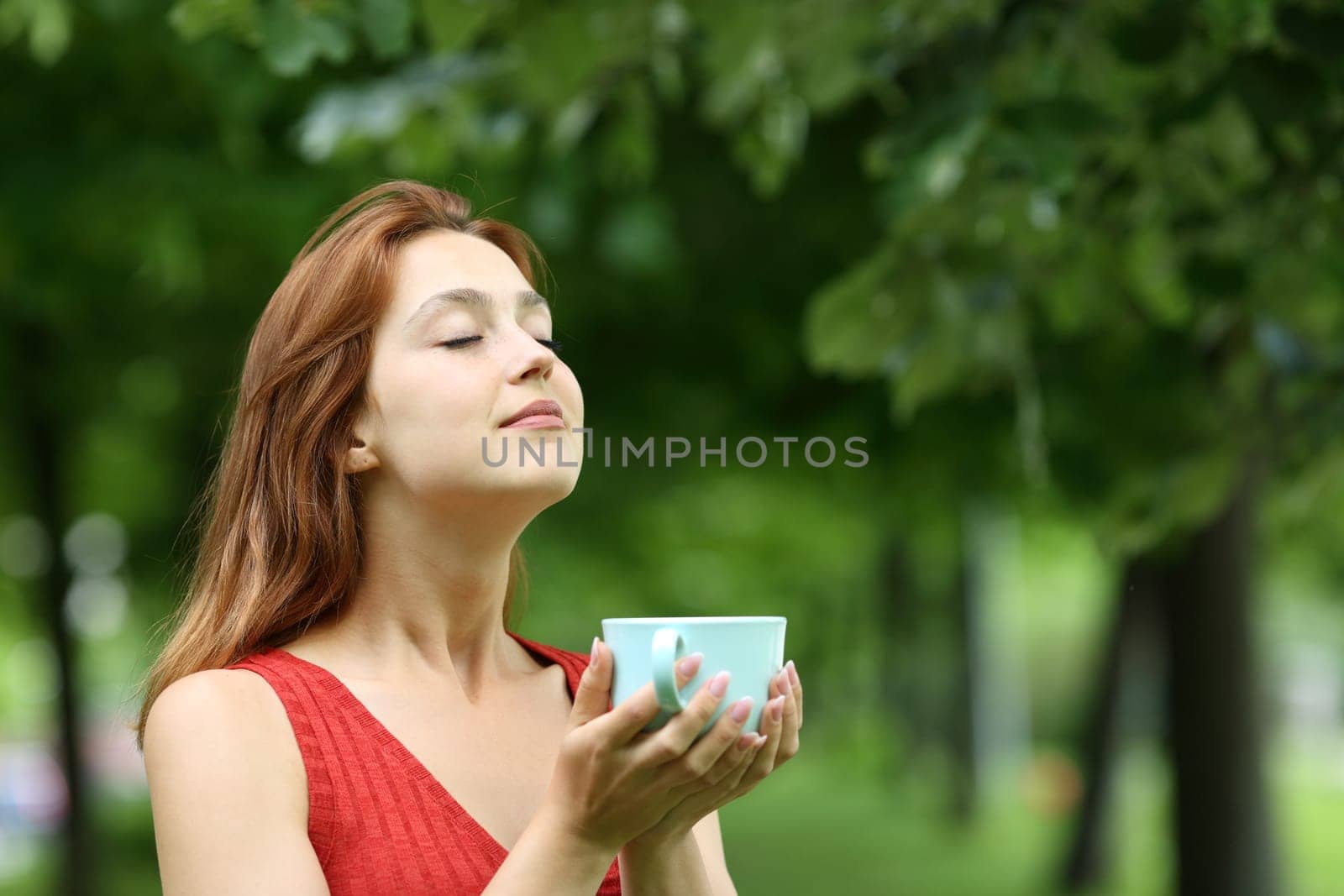 Woman holding coffee cup breathing fresh air