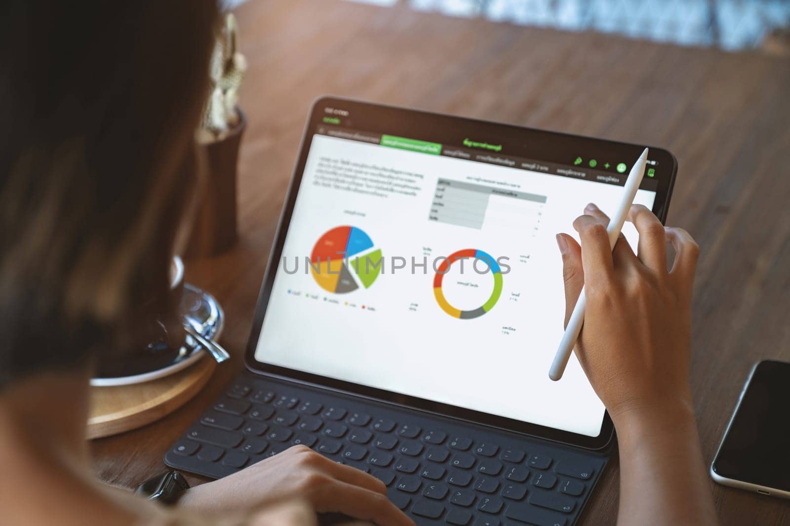 A woman using digital tablet third person view