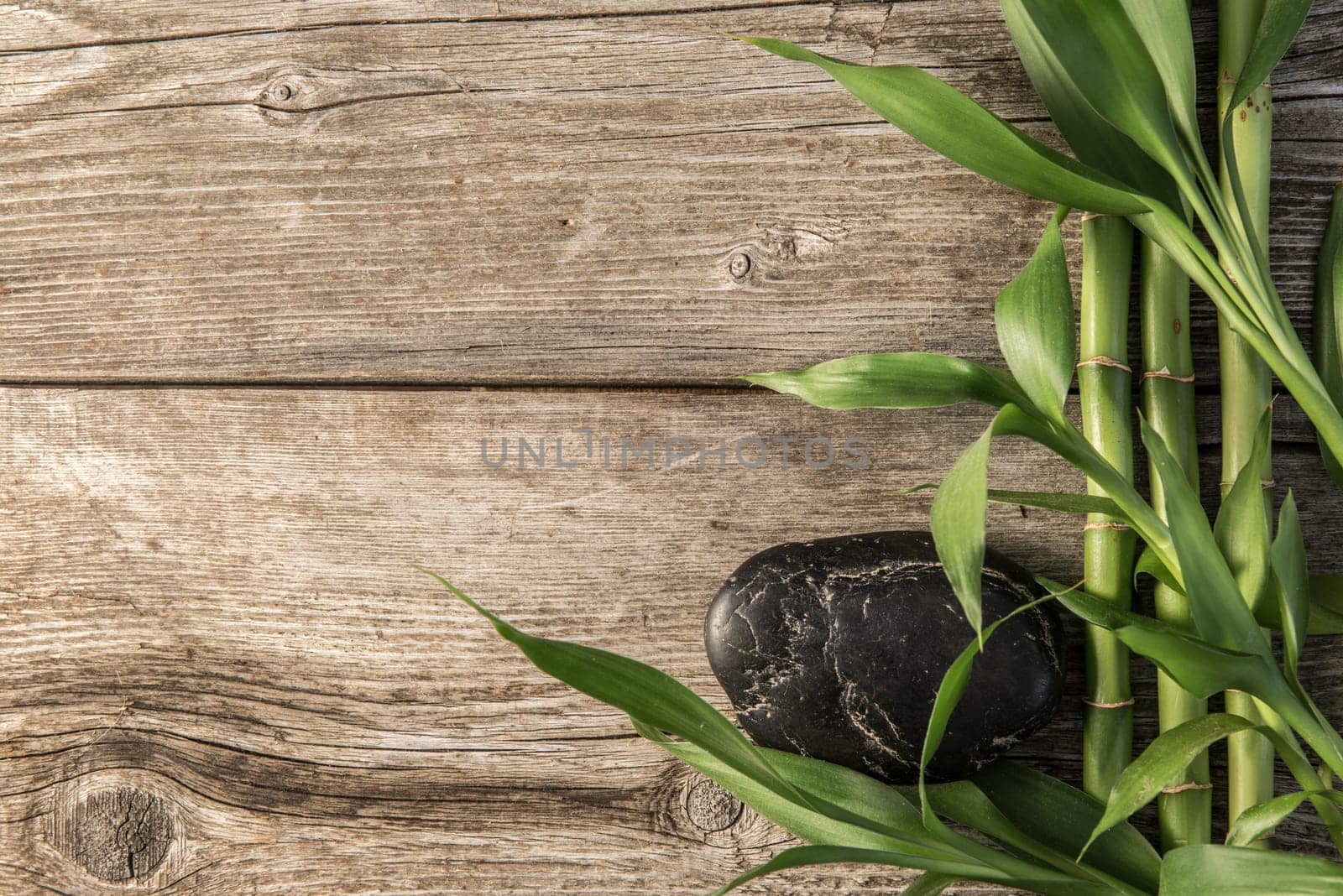 zen basalt stones and bamboo on the wooden baord background