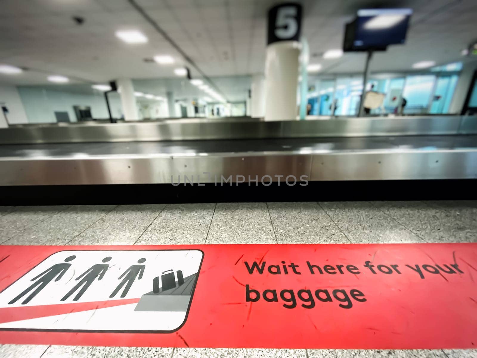 A red patch on the floor indicating where to wait for baggage claim at an airport. Icons and pictogram. Arrival at the airport