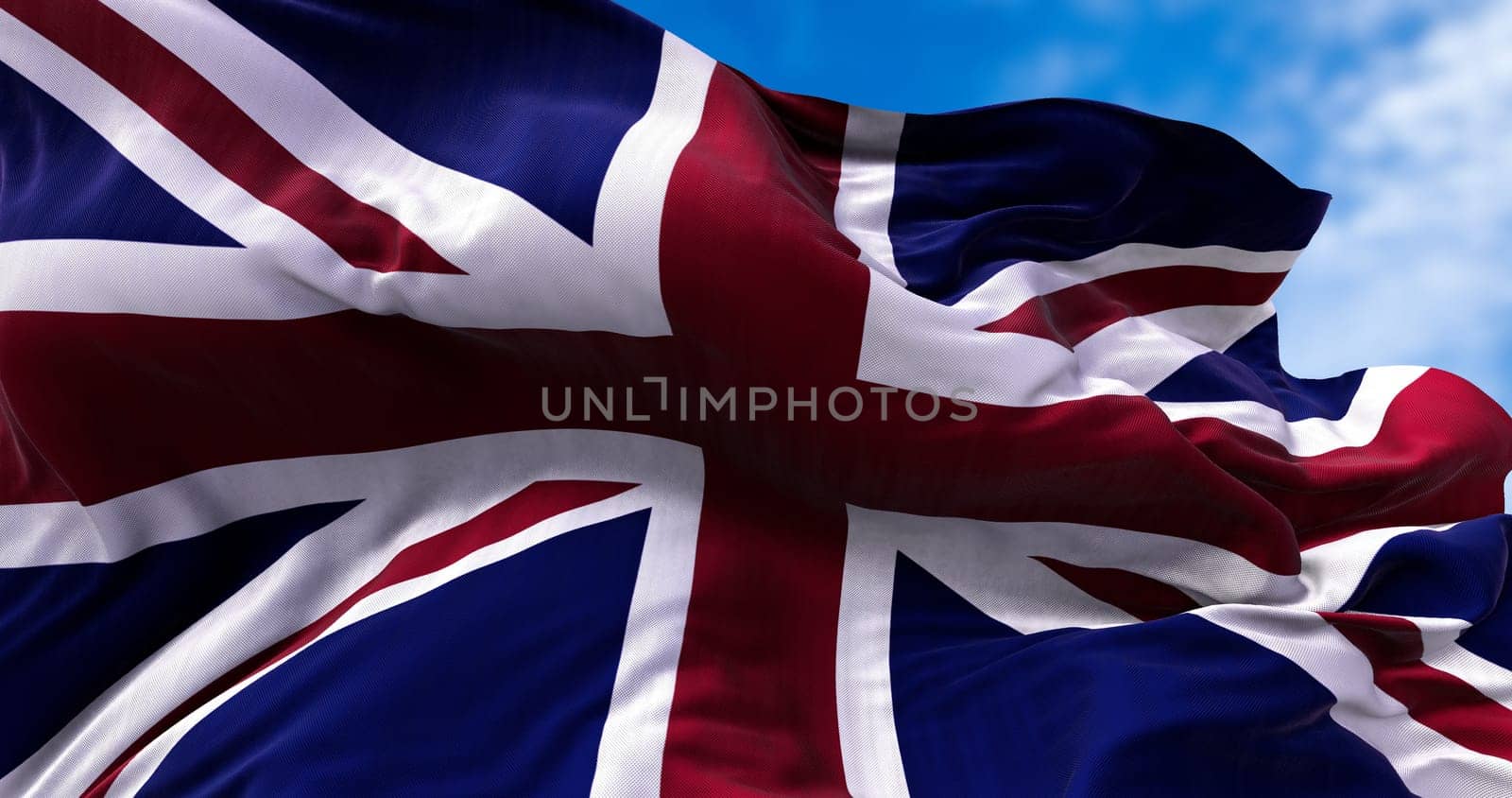 The national flag of the United Kingdom flying in the wind. Outdoors and sky in the background.