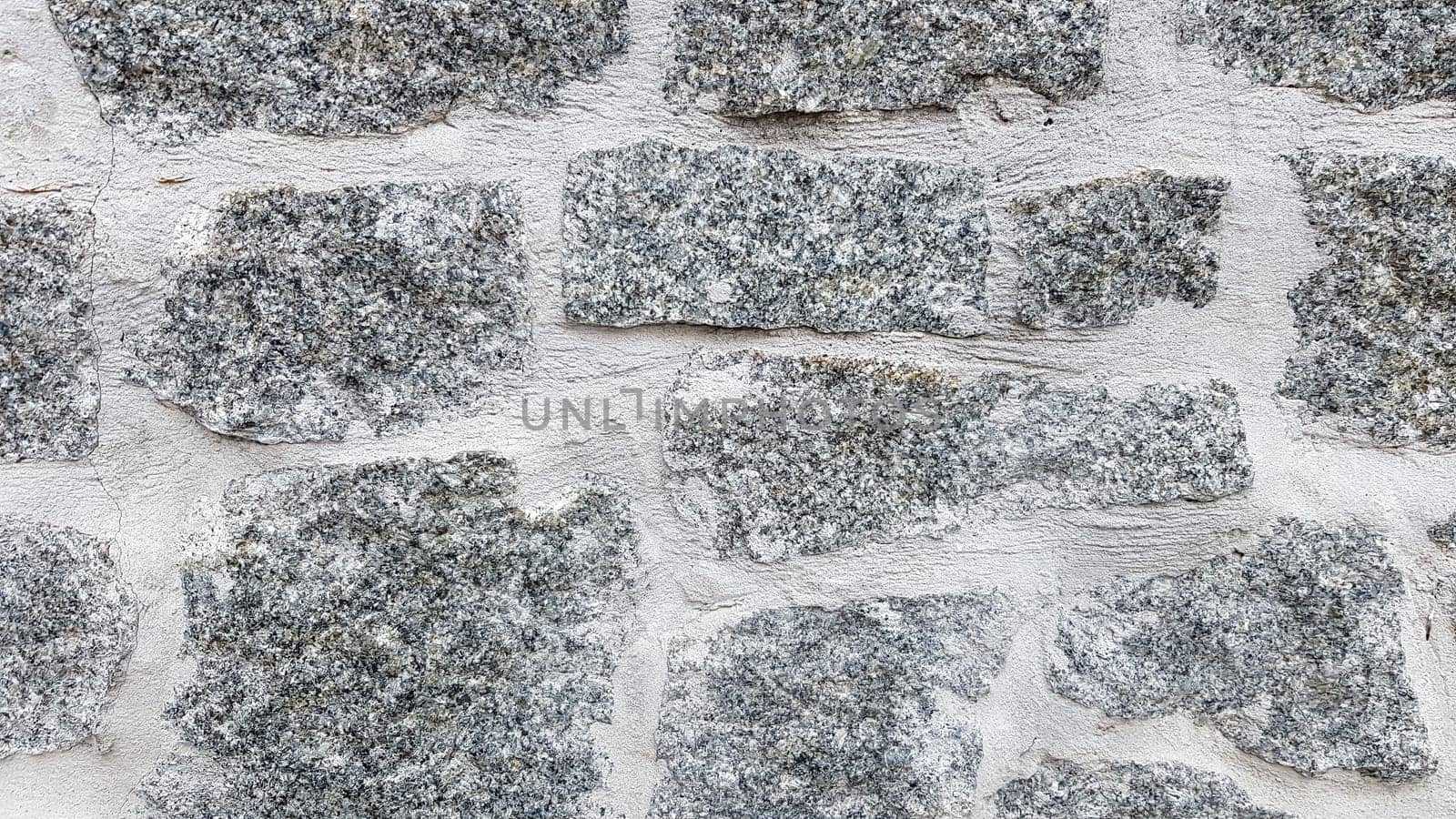 Gray stone wall background. The texture of the stone. Old castle wall background. Stone wall as a background or texture. Part of the wall, for background or texture