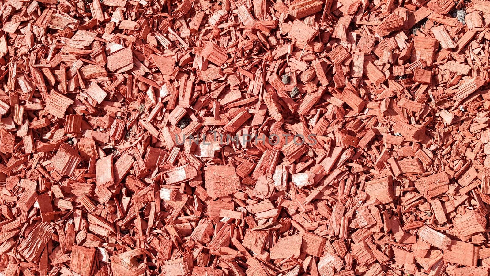 Sawdust for the garden. Texture of tree bark lying on the ground. Background from a tree bark. Decorative bark, mulch, mulching. Decorative wood chips. Natural pine red mulch.