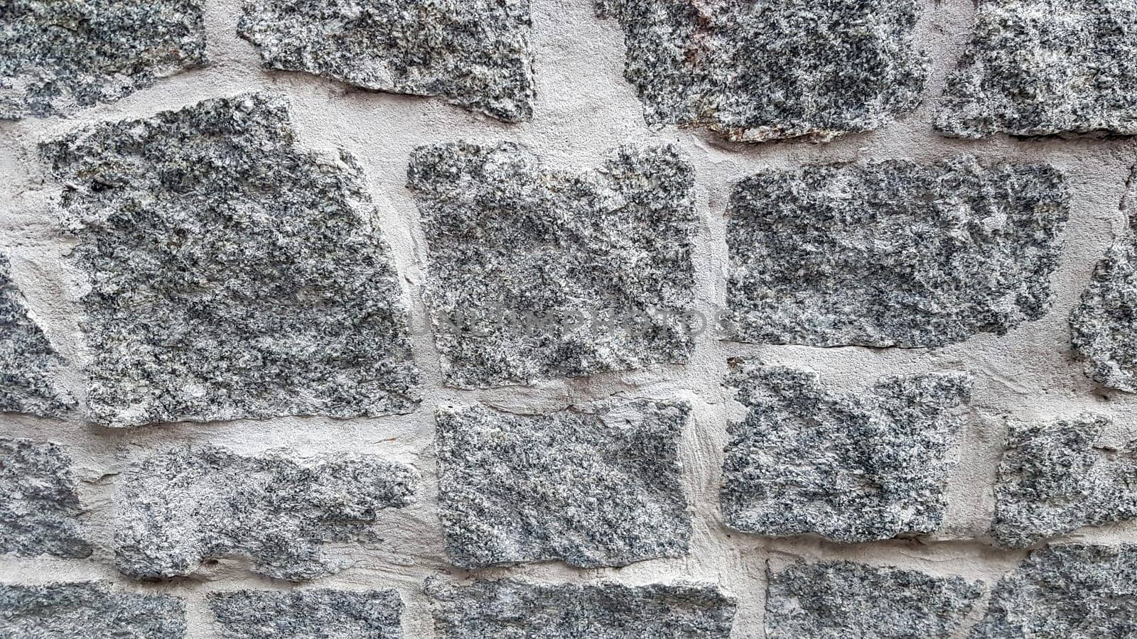 Gray stone wall background. The texture of the stone. Old castle wall background. Stone wall as a background or texture. Part of the wall, for background or texture