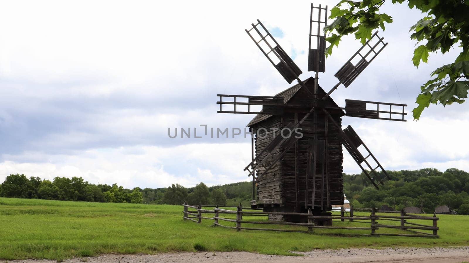 Ukraine, Kiev - June 11, 2020. Old Ukrainian wooden windmills of the XIX century. Summer outdoor landscape. Open-air museum of folk architecture and life, Pirogovo, Ukraine. Tourism and travel