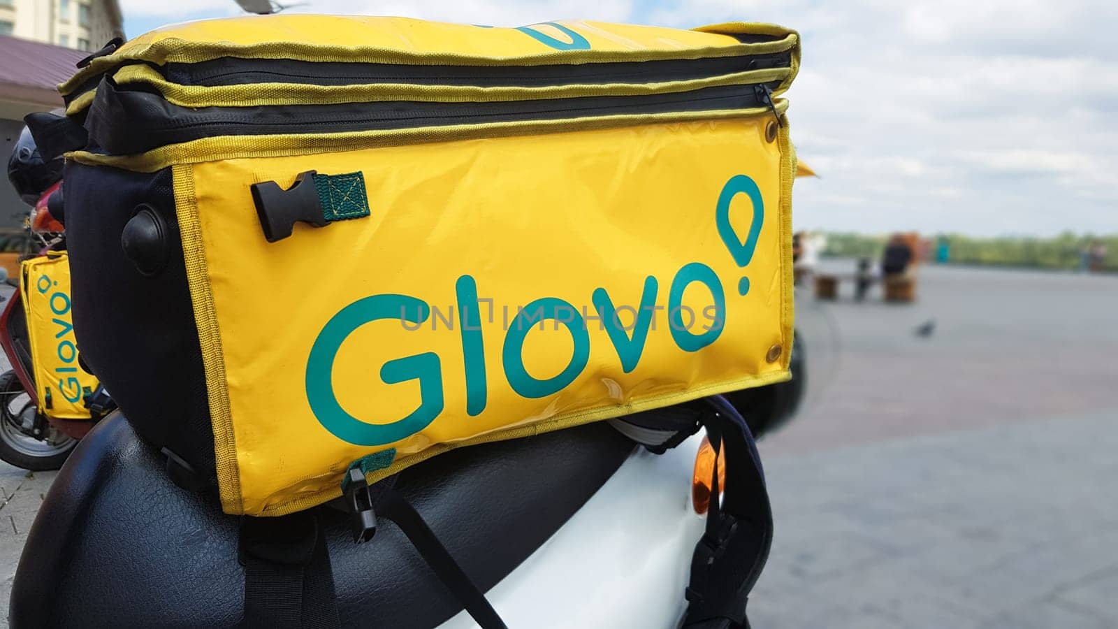 Ukraine, Kiev - August 29, 2020. Parked moped with yellow bag with Glovo logo near McDonald's close-up. Courier service that delivers goods ordered through a mobile application. Editorial photography