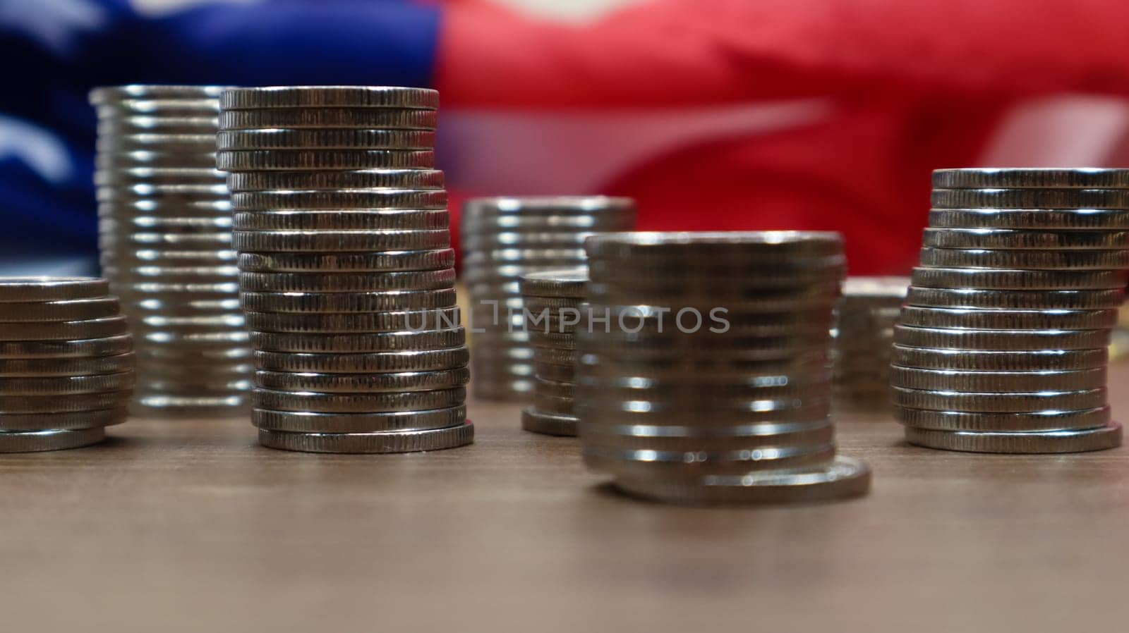 American coins with the flag of the United States of America. Investment concept, business finance and money saving. US coins stacked against the background of the American flag. Selective focus