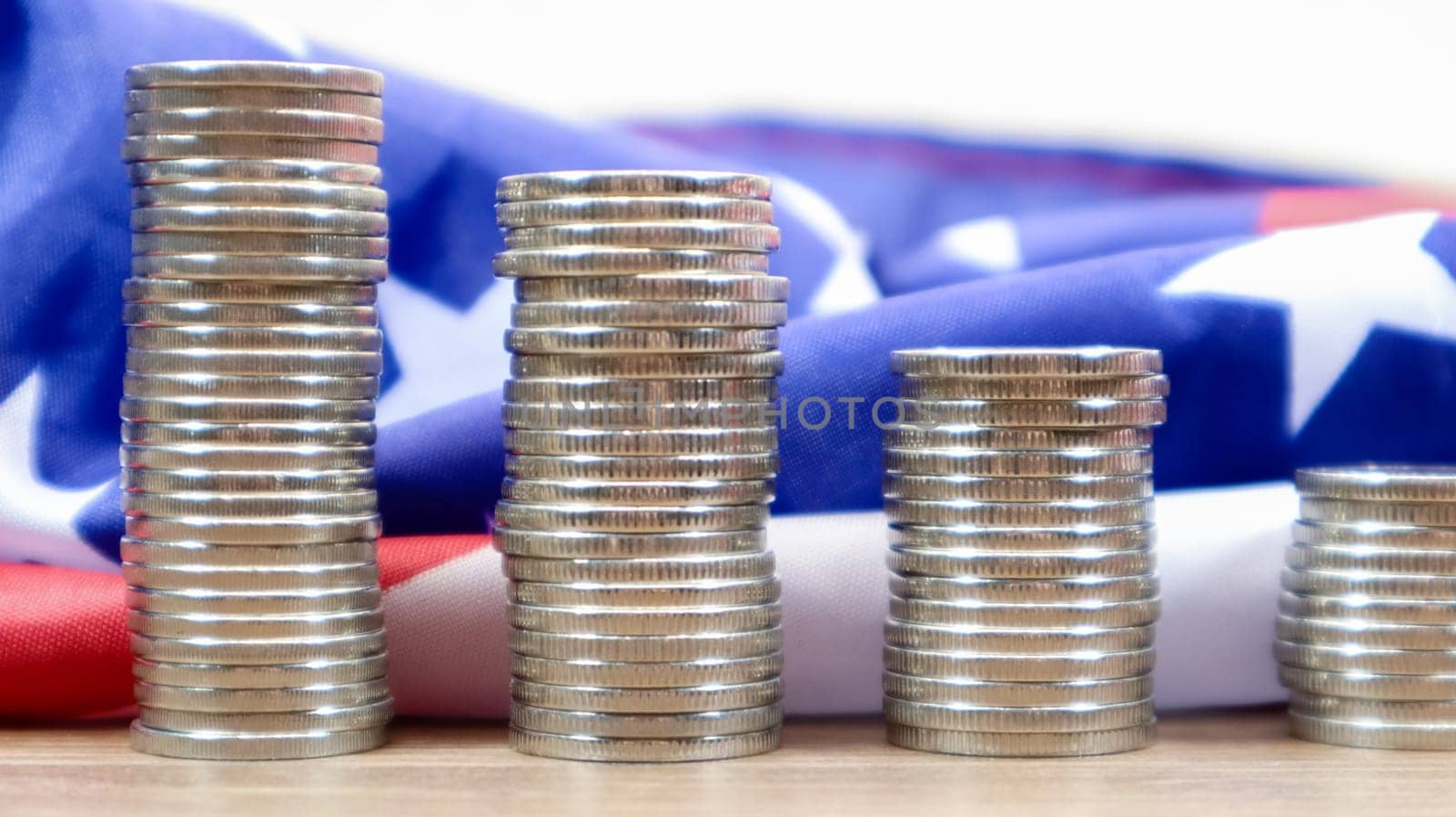 American coins with the flag of the United States of America. Investment concept, business finance and money saving. US coins stacked against the background of the American flag. Selective focus