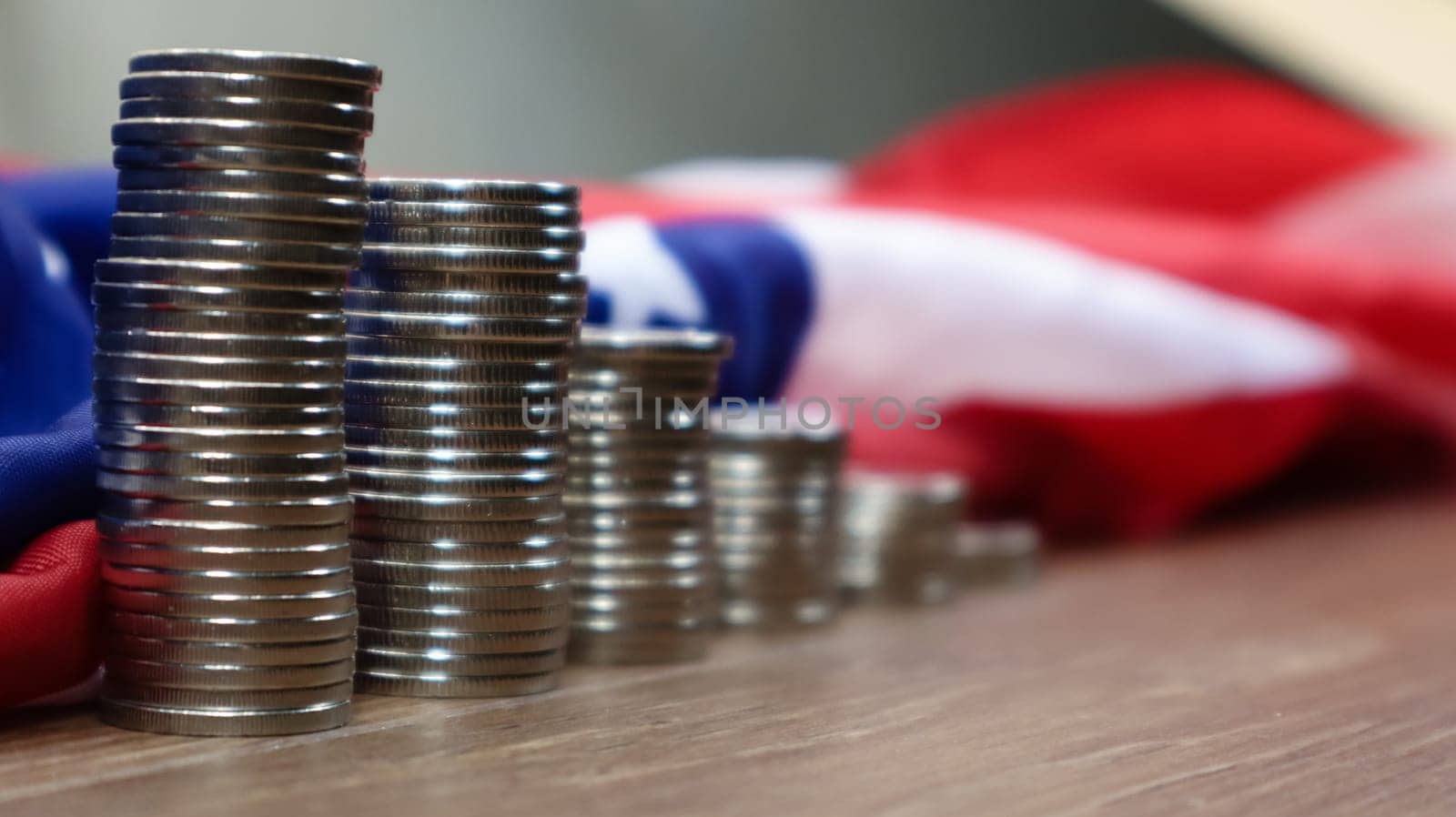 American coins with the flag of the United States of America. Investment concept, business finance and money saving. US coins stacked against the background of the American flag. Selective focus