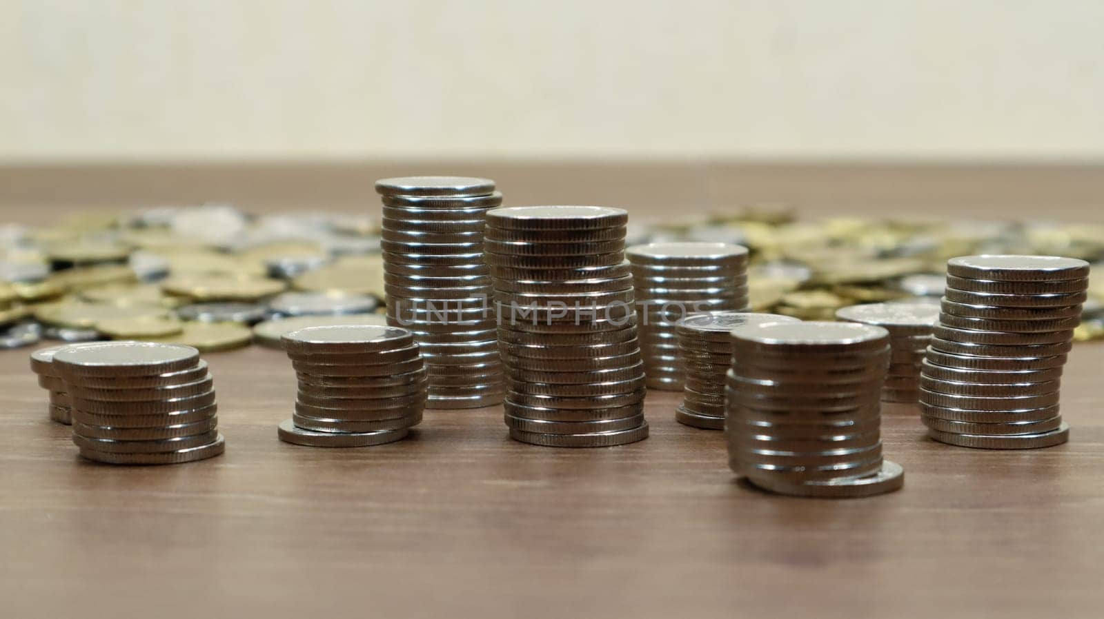 Coins are stacked on a wooden work table. Stock photo of many cents