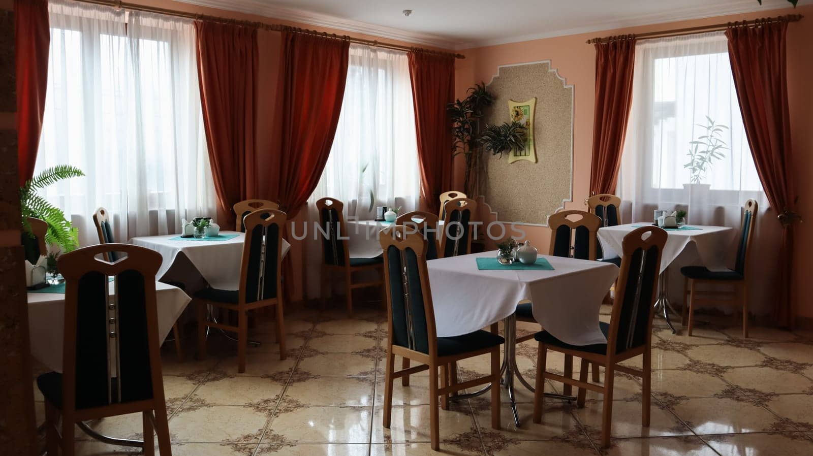Served tables for breakfast in the cafe, restaurant or hotel dining room. An empty hall, no people. Ukraine, Yaremche - November 20, 2019.