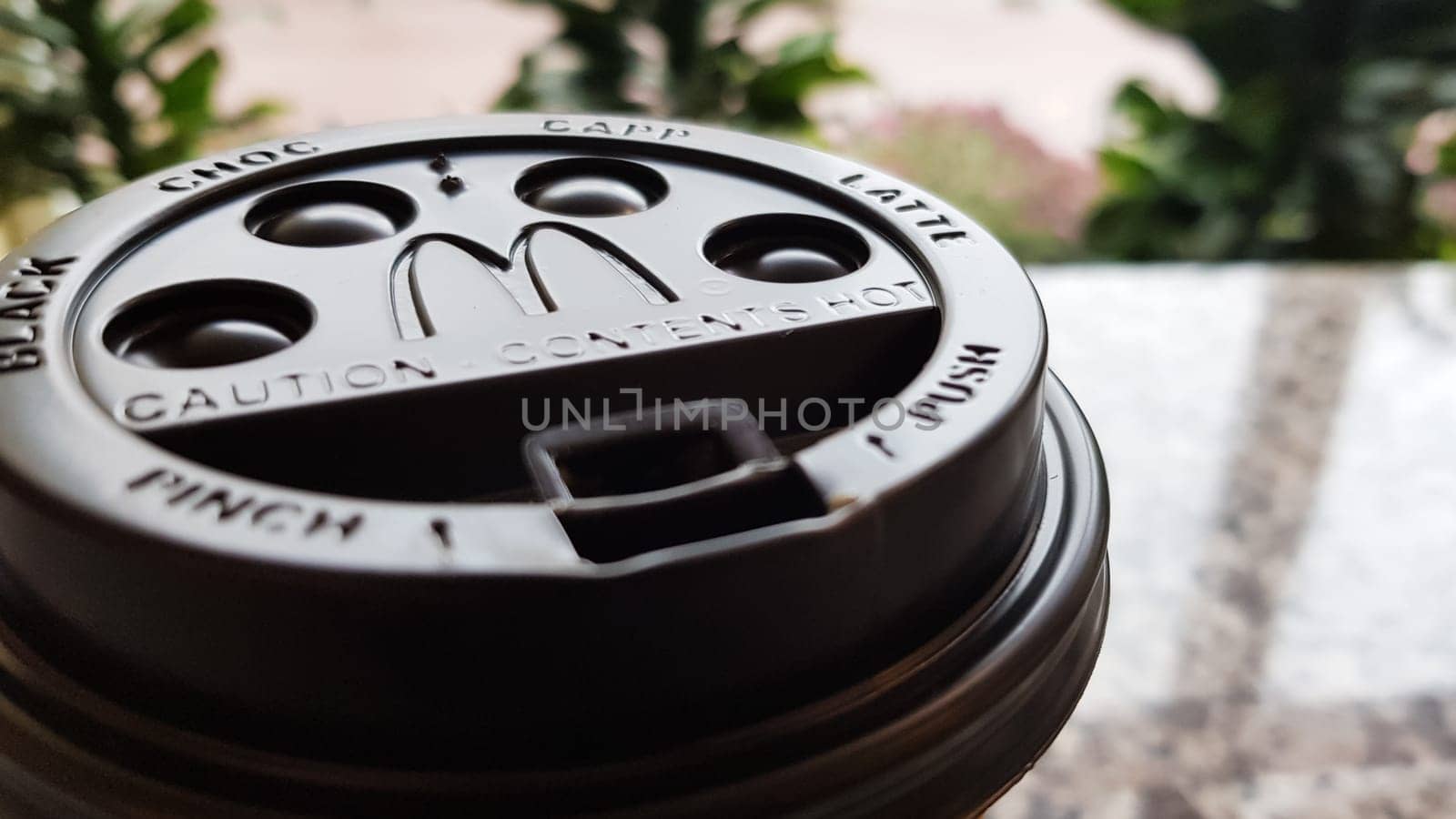 Close-up of McDonald's fast food restaurant logo on a black paper cup lid with hot McCafe coffee. Breakfast, coffee time. Ukraine, Kiev - September 30, 2020