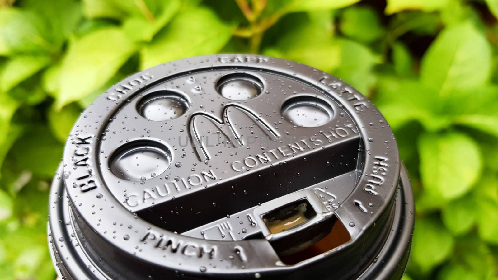 Close-up of McDonald's fast food restaurant logo on a black paper cup lid with hot McCafe coffee. Breakfast, coffee time. Ukraine, Kiev - September 30, 2020
