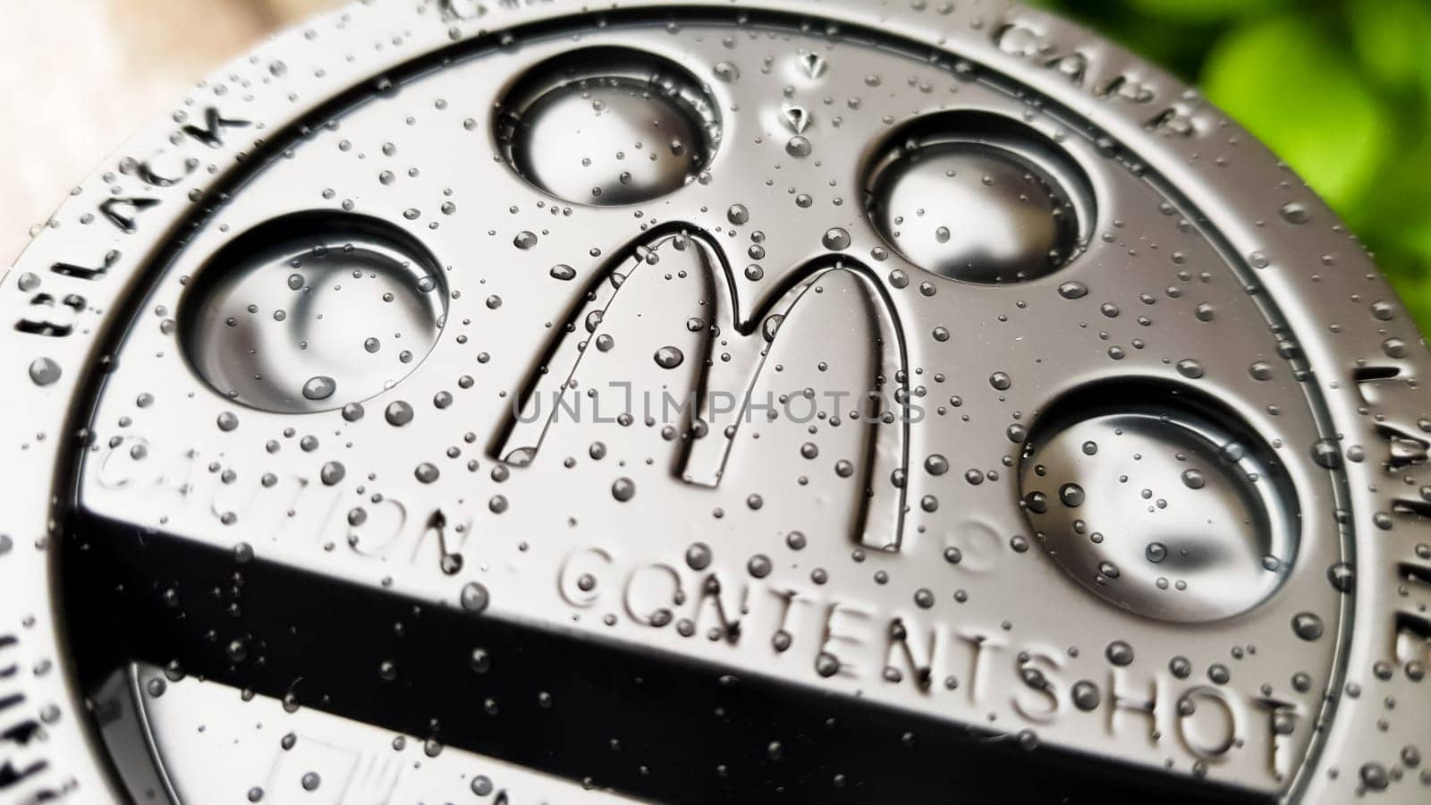 Close-up of McDonald's fast food restaurant logo on a black paper cup lid with hot McCafe coffee. Breakfast, coffee time. Ukraine, Kiev - September 30, 2020