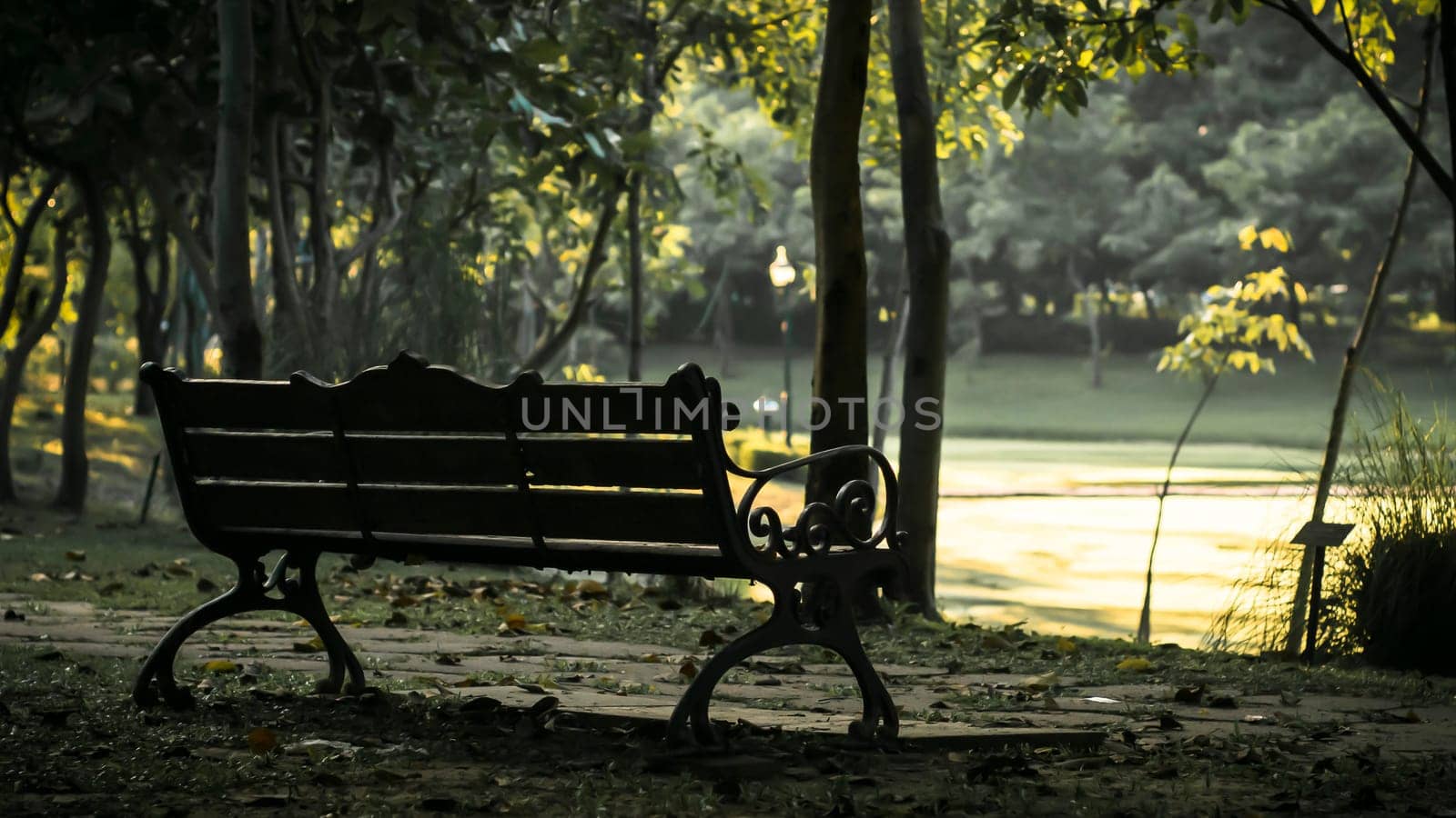 Background of city park in spring with trees, bushes and bench. island  and the lake