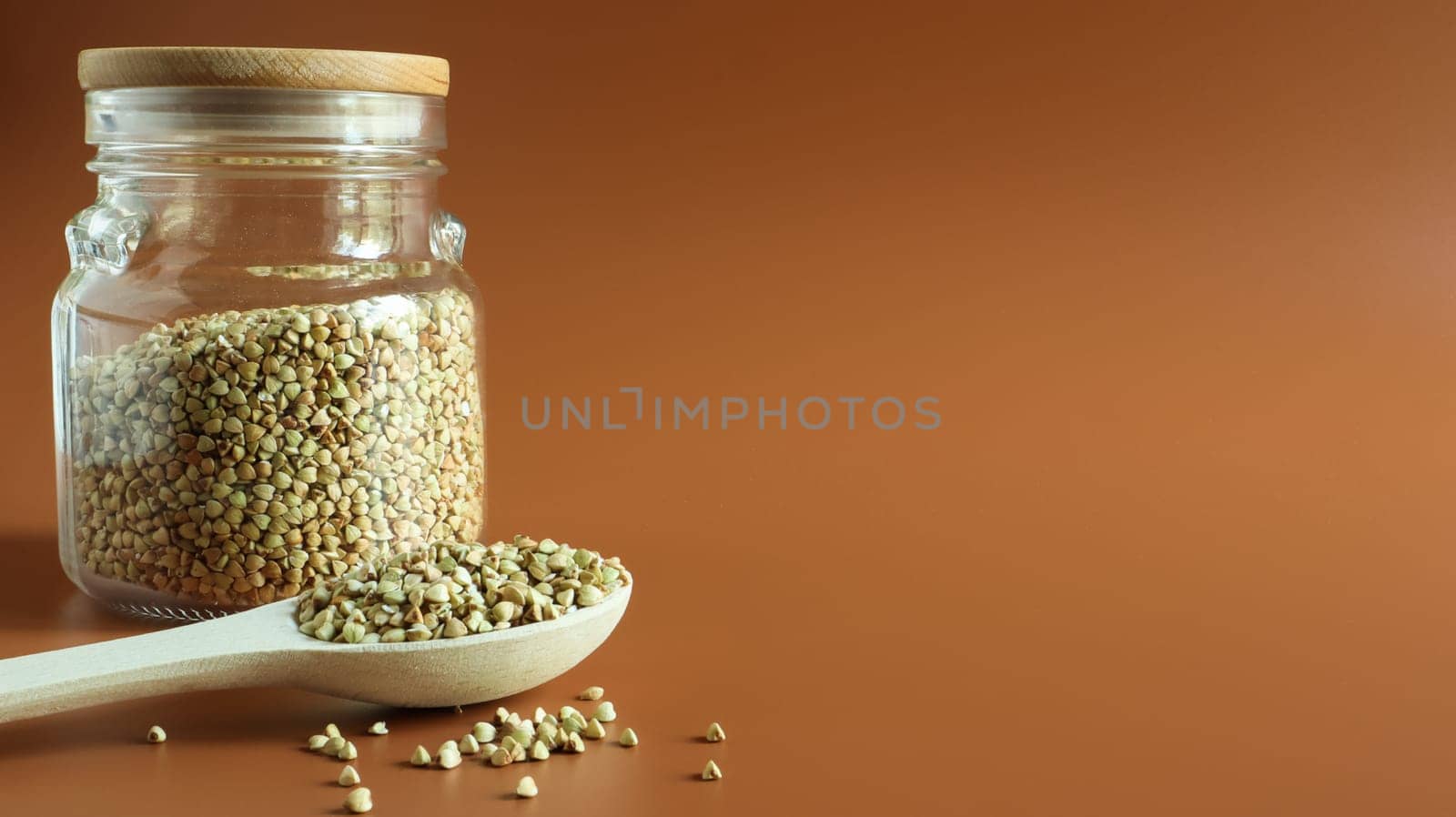 Green buckwheat sprouts in a glass jar with a wooden spoon. Raw vegan food concept. Organic food. The concept of diet, weight loss, healthy and proper nutrition. Copy space. Space for text