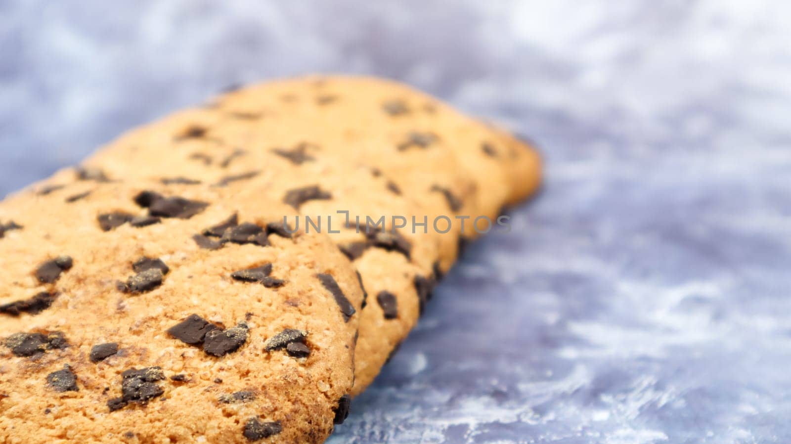 Soft, freshly baked chocolate chip cookies on a gray marble kitchen countertop. American traditional sweet pastry pastry, delicious homemade dessert. Culinary background. Copy space.