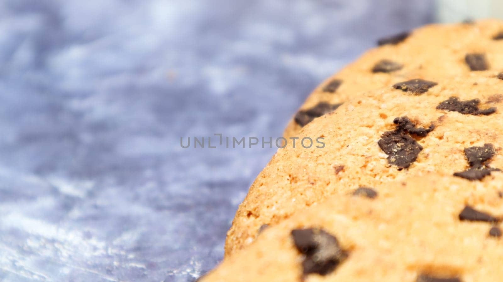 Soft, freshly baked chocolate chip cookies on a gray marble kitchen countertop. American traditional sweet pastry pastry, delicious homemade dessert. Culinary background. Copy space.